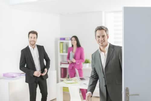 Image of an open office door with three people inside